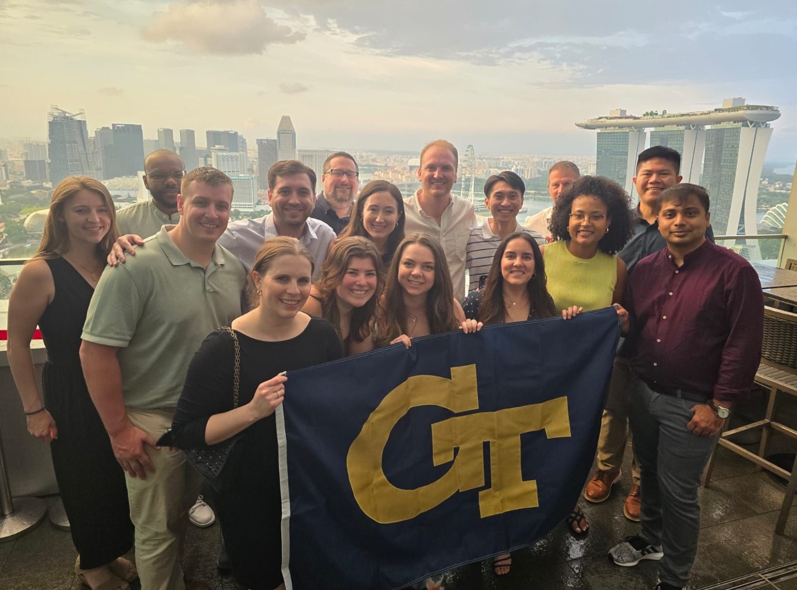 A group of students pose with Georgia Tech flag. 