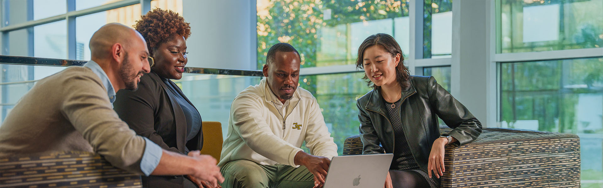 Four Scheller student meeting around table with laptop