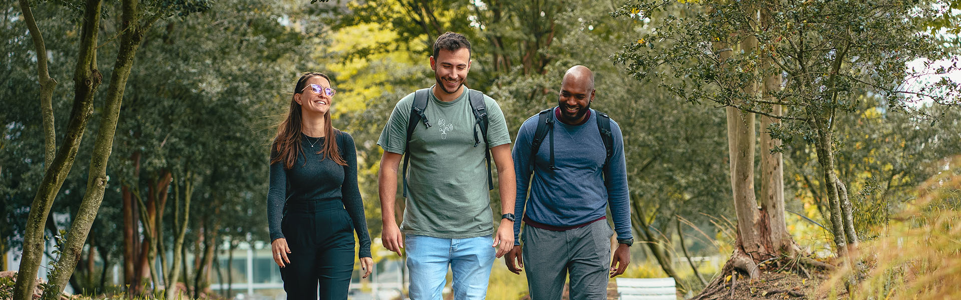 Three casual Scheller students walking with backpacks outside