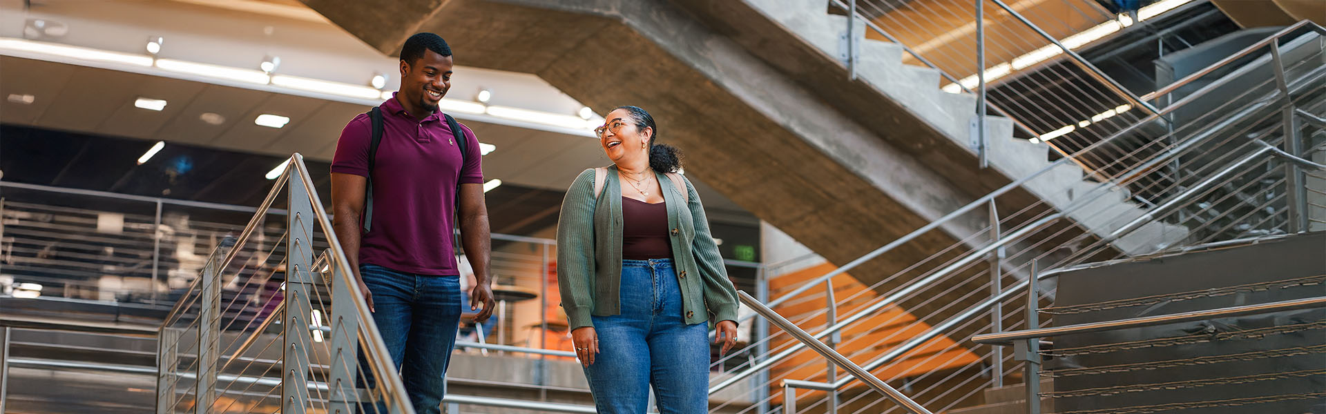 Two Scheller MBA students walking down stairs chatting with each other