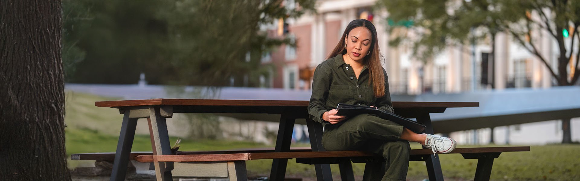 Female Scheller student outside on bench