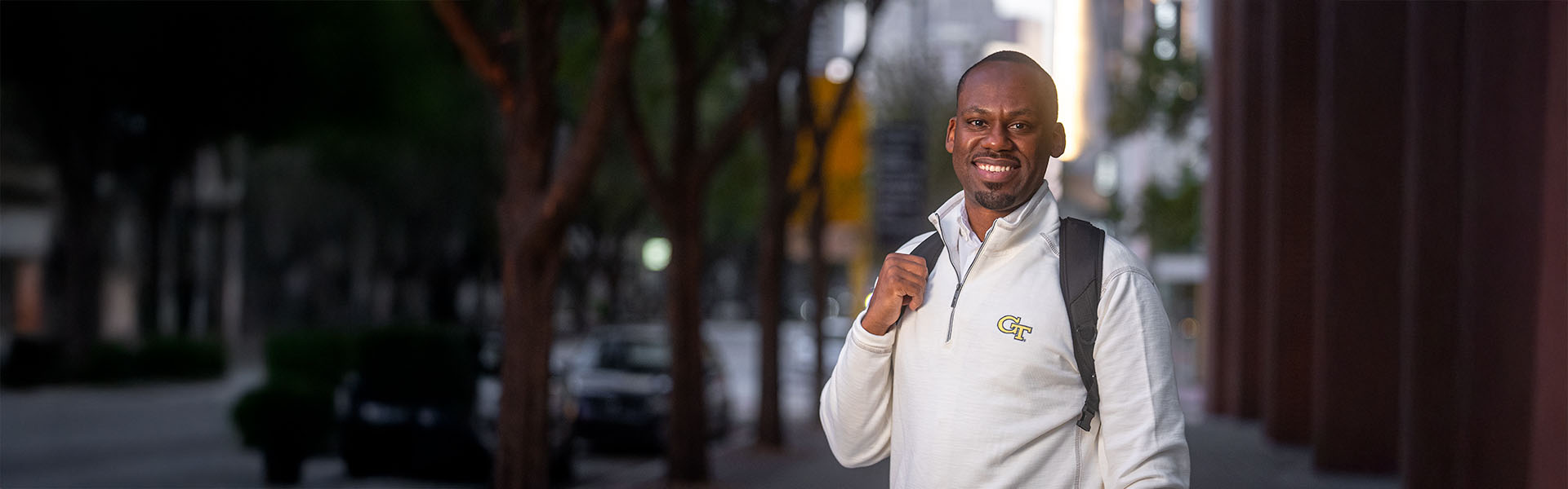 Scheller student posing outside in Midtown wearing a white GT shirt