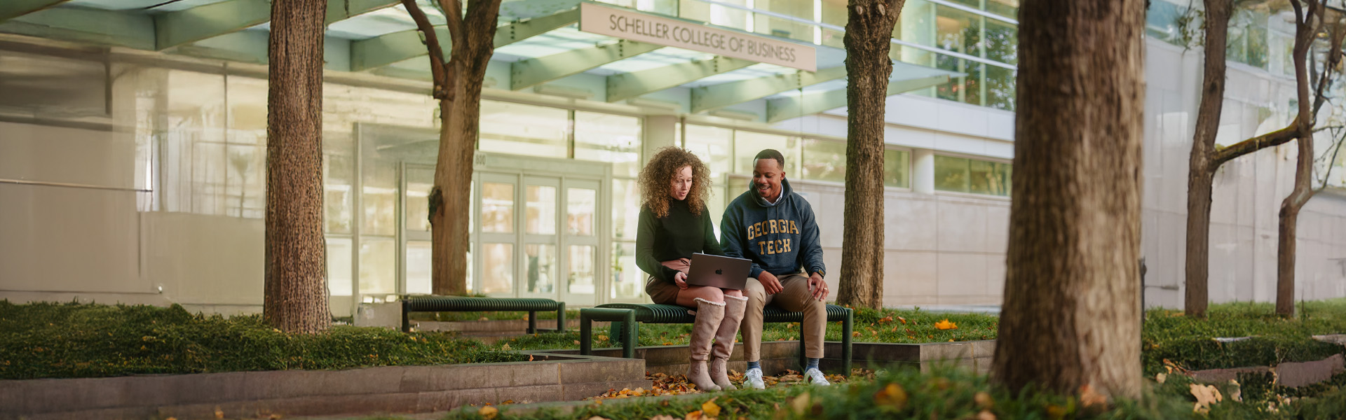 Two student looking at laptop outside of Scheller building