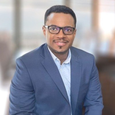 Rodney Mays, Executive MBA ’23, looks at the camera wearing a navy-blue suit jacket    