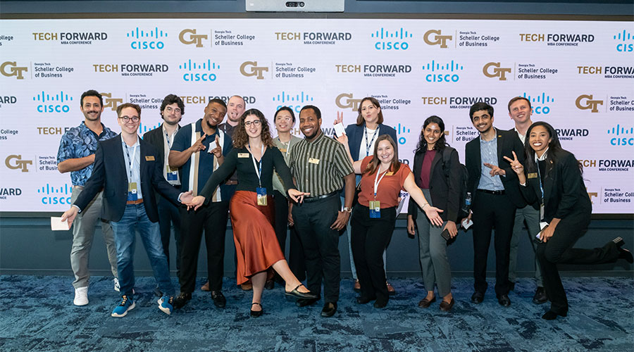 Conference attendees and Scheller MBA students take a group photo in front of the digital signage.