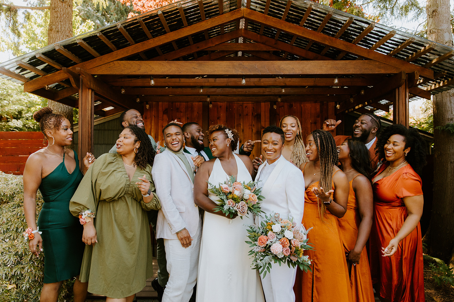 Two women stand in white surrounded by family and friends