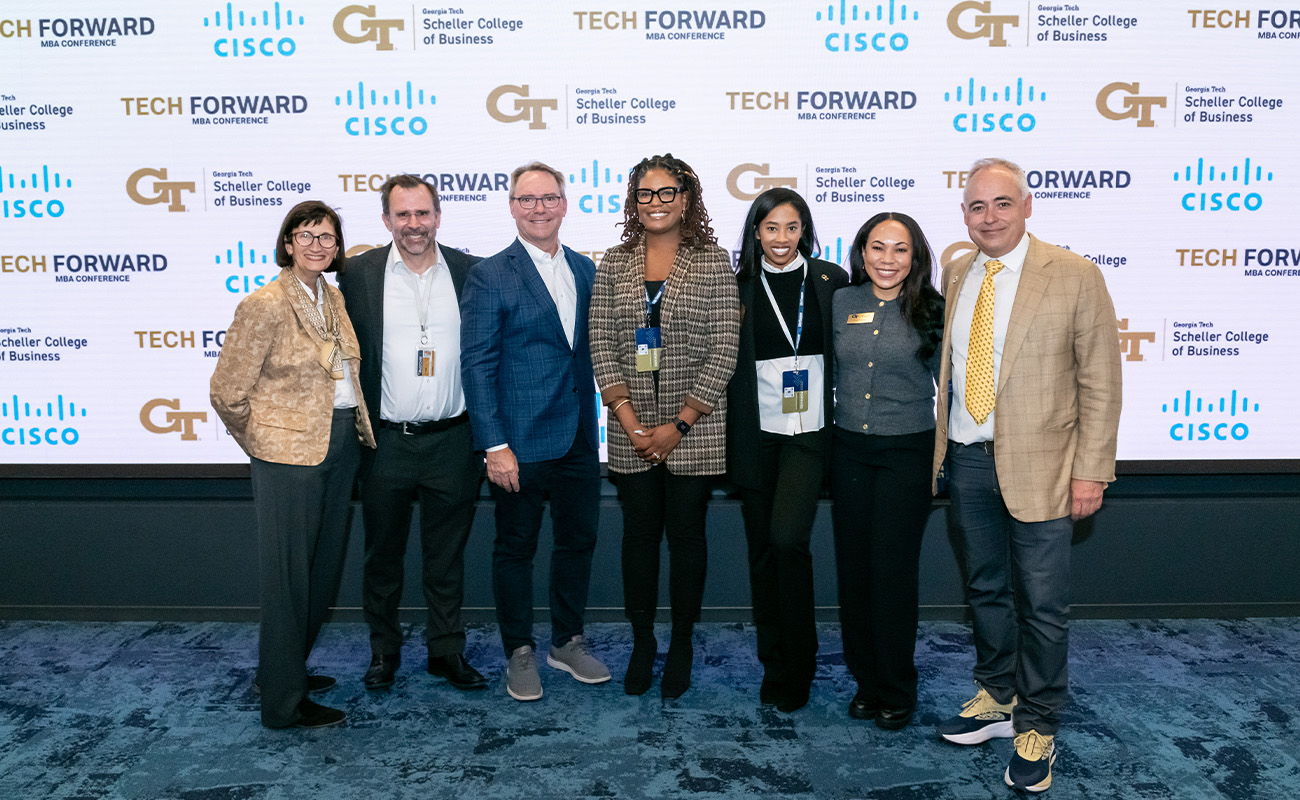 A group of women and men smile at the Tech Forward Conference