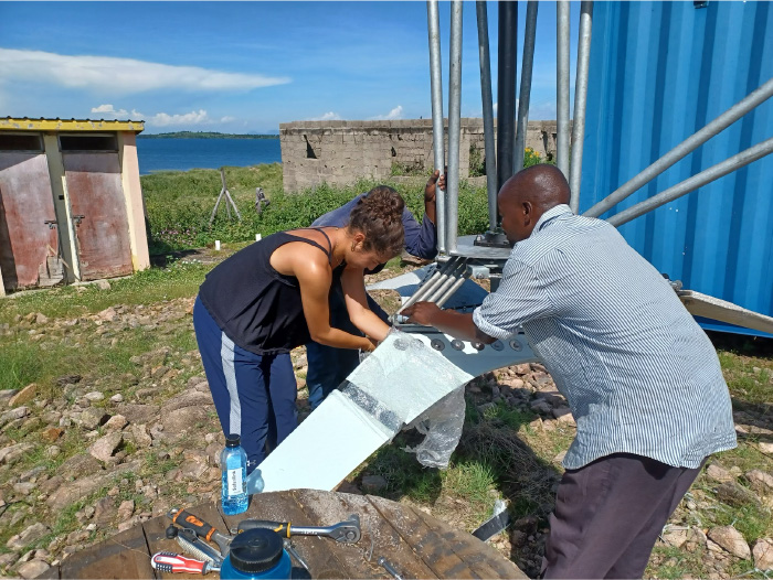 Amanda Ehrenhalt performs maintenance on a wind-turbine alongside Site Technician George Ochieng.