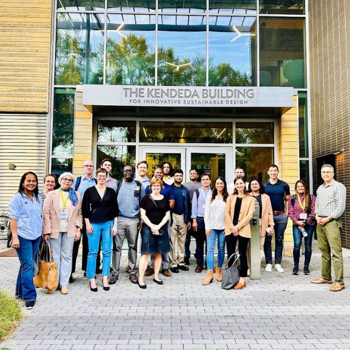 a group of Scheller EMBA students standing outside the entrance of the Kendeda Building