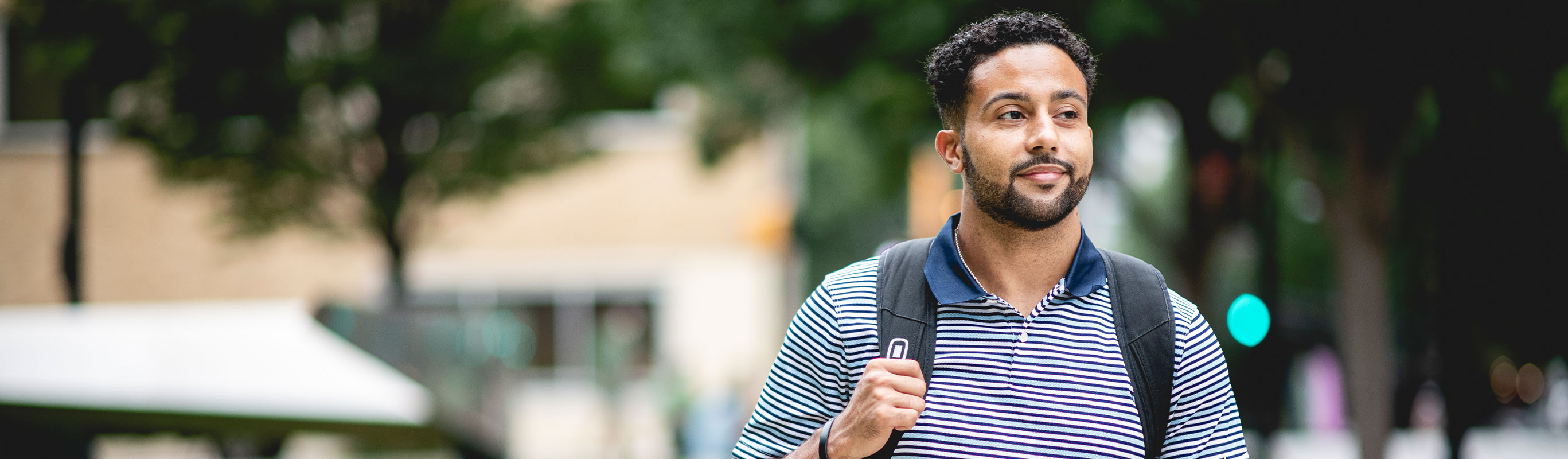 Male Scheller MBA student carrying a backpack